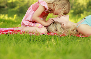 Mama and her little daughter lie on the grass